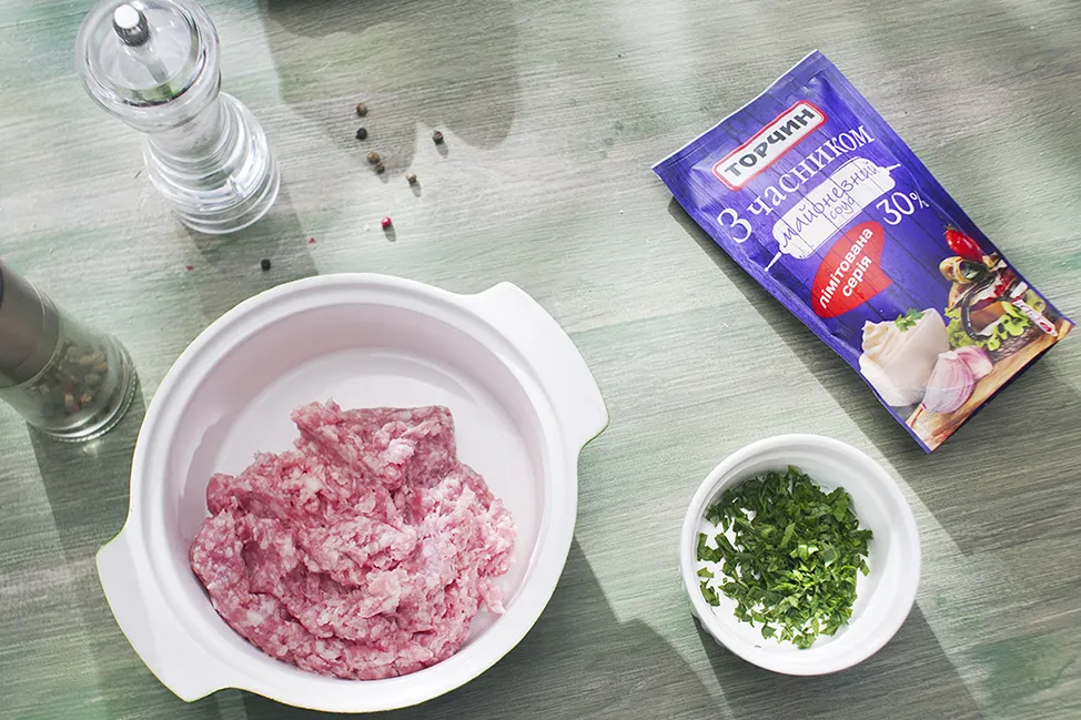 Фарш змішайте з майонезом і подрібненою зеленню, посоліть і поперчіть.
