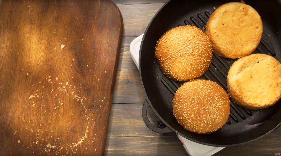 Булочки підсушіть на сковороді, попередньо розрізавши їх навпіл. Помідори наріжте кружальцями.