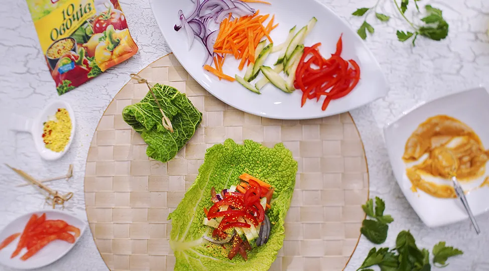 У центр листка капусти викласти начинку, соус і загорнути рулет конвертиком.